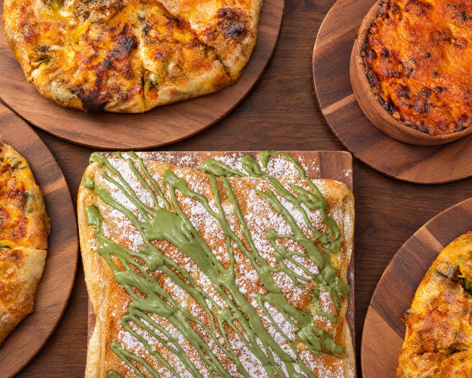 Savory and sweet feteer and macarona bechamel on wooden boards, ready to share